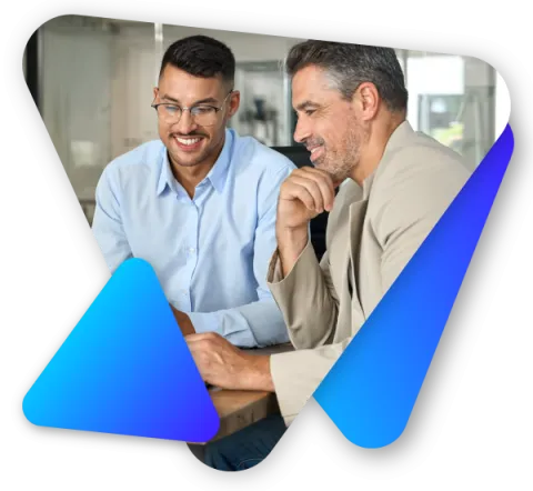 Two men smiling and looking at a laptop screen in a bright office setting.
